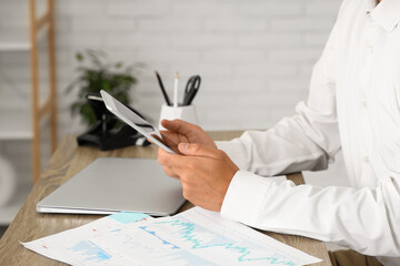 Wall Mural - Handsome businessman working with tablet computer at desk in office, closeup