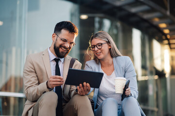 Business people having fun using digital tablet outdoors