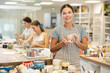 © JackF - Young female teacher in apron with handmade ceramic cup posing in ceramics workshop