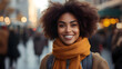 © Siasart Stock - Smiling woman with curly hair and orange scarf in a city setting.