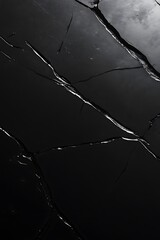 Leinwandbilder - A dark surface with visible cracks, reflecting light, creating an artistic contrast between shadow and shine.