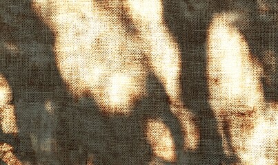 Leinwandbilder - Soft, filtered light casts a warm glow on a textured, natural fabric background, creating an inviting and serene atmosphere.