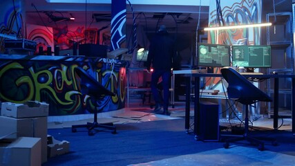 Aufkleber - Hooded hacker arrives in neon lit underground shelter filled with graffiti artwork. Cybercriminal enters colorful painted basement, starting work on script that can crash businesses servers, camera A