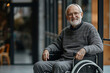 © stanhert - A smiling older man in a gray sweater sitting in a wheelchair