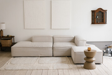 White sectional sofa is in minimalistic scandinavian living room