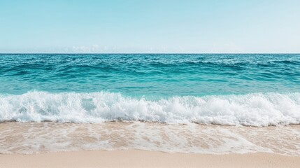 A serene beach scene featuring gentle waves lapping at the shoreline under a clear blue sky.