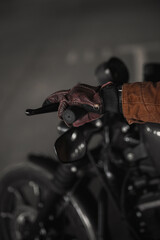 Photograph of a person's hand holding the handlebars of a motorcycle