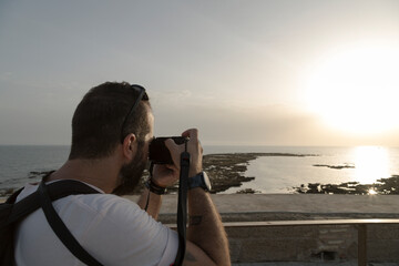 Wall Mural - relaxing image of A man photographs a seaside sunset