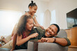 © peopleimages.com - Laughing, tickle and support with family on sofa for love, playful game and happiness together. Care, energy and funny with father and children in living room at home for silly, comedy and joke