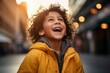 © Igor - happy african american little girl in yellow jacket on city street