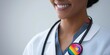 © Anzhela - Confident healthcare professional with stethoscope and rainbow pin in clean medical environment