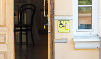 A door is open to a room with a yellow sign that says handicap