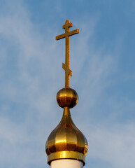 A gold cross is on top of a building