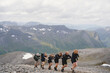 © Johnér - Group of friends climbing in row on mountain against cloudy sky