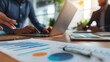© Andrew - Strategic Business Meeting: A close-up shot focuses on financial charts and graphs during a business meeting, emphasizing collaboration and data analysis.