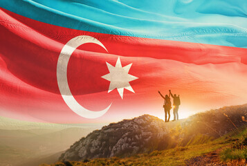 Azerbaijan flag waving in the sky. A couple hike and enjoy a break look at the top of the mountain adventure travel. Azerbaijan national flag for independence day.