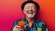© BerkahStock - A cheerful older man in a vibrant shirt enjoys a colorful drink against a bright background.