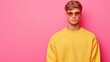 © Nut S. - Portrait of caucasian European man in a yellow shirt is wearing sunglasses and standing in front of a pink background. the man is dressed in bright colors.