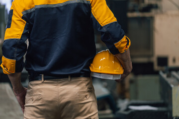 Caucasian engineer using a laptop in a factory. man working in plastics factory.