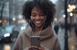 © Georgii - A cheerful woman with curly hair smiling while listening to music on her phone during a rainy day in the city