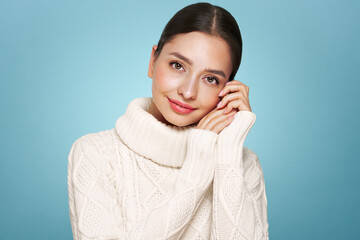 Wall Mural - portrait of young happy beautiful woman smiling and looking away, isolated on blue background in a w