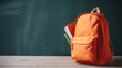 © Anuyj - books on table and background for studying, learning and research in education, Orange school bag blurred background