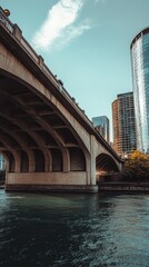 Concrete bridge spanning river with modern buildings in background