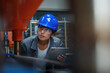 © 24K-Production - Indian woman engineer with a blue helmet holding a tablet, doing factory working machine inspection, checking productivity and accuracy, close up shot.
