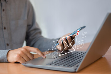 Wall Mural - man uses laptop with notification icon of two new email messages. communication business technology.
