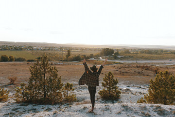 victorious hiker celebrating on scenic hilltop overlooking lush countryside landscape