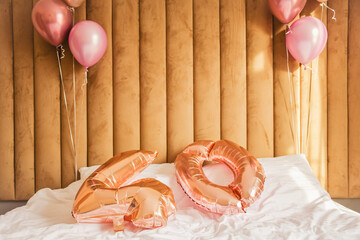 Number forty balloons on bed on birthday party with blank wall background