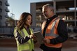© useful pictures - Civil engineer discusses project details with a contractor at a construction site during the day