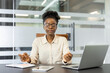 © Liubomir - African American businesswoman enjoys peace while meditating at office desk. Mindfulness practice enhances focus and reduces stress amid work tasks, promoting relaxation and balanced workflow.