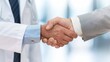 © Radomir Jovanovic - A healthcare professional and a business partner shake hands to signify a collaborative agreement in a modern medical facility
