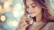 © Amirian - A beautiful woman in a sweater holding a bottle of perfume and smiling.
