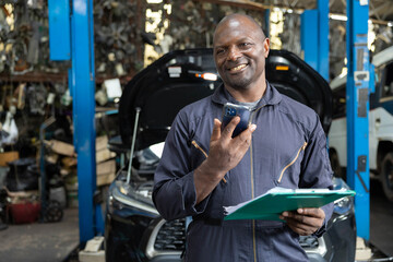 male worker talking on smartphone with customer in garage