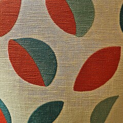 Colorful fabric pattern with red and green leaf shapes on a textured beige background.