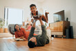 © peopleimages.com - Bonding, airplane and lifting with family on floor for love, playful game and happiness. Care, support and laughing with child and parents in living room at home for silly, comedy and funny