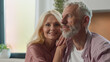 © Yuliia - Happy smiling dreaming Caucasian married family couple in love man woman husband wife hugging hug cuddle in living room together bonding relationship mature homeowners apartment renters enjoying dream