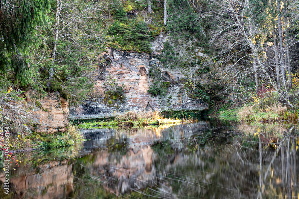 Brasla sandstone outcrops on the bank of Brasla river, colorful trees in ...