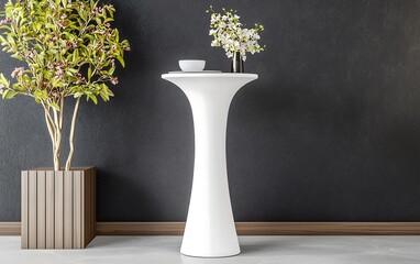 A modern white pedestal table with a decorative flower arrangement beside a textured dark wall, enhancing the contemporary decor.