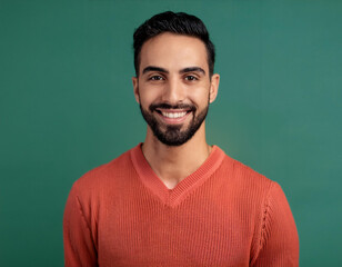 Studio Portrait of Handsome Young Man Happily Smiling Against Green Background