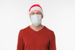 © InsideCreativeHouse - Grey-haired man in red Santa Claus hat wearing protective face mask against coronavirus Covid 19 isolated in white background. Pandemic Christmas New Year concept