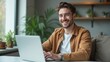 © Trust Fish - Smiling Young Man on a Video Call in a Modern Apartment with Plants