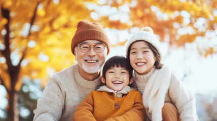 Wall Mural - A joyful grandfather poses with his two cheerful grandchildren amidst vibrant autumn leaves, capturing heartwarming family moment filled with love and laughter