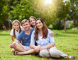 © peopleimages.com - Parents, kids and smile in portrait at park for holiday, relax and relationship with love in nature. Happy family, people and girl children on grass for weekend together, safety and support with care