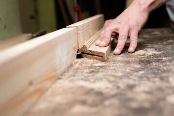 The carpenter makes a horizontal cut in an oak part