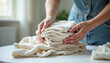 © Ali Hamza Tullah - Feel softness, chore of pretty asian young woman hand holding pile clothing from table, stack folding clean clothes after washing, laundry and dry. Household working at home. Laundry of maid concept.
