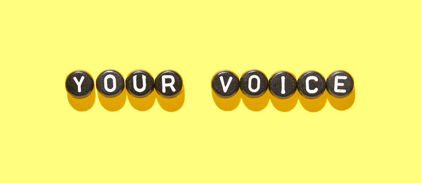Your voice concept with letter beads on bright yellow background for communication and expression themes.