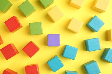 Sticker - Many wooden colorful cubes on yellow background, flat lay